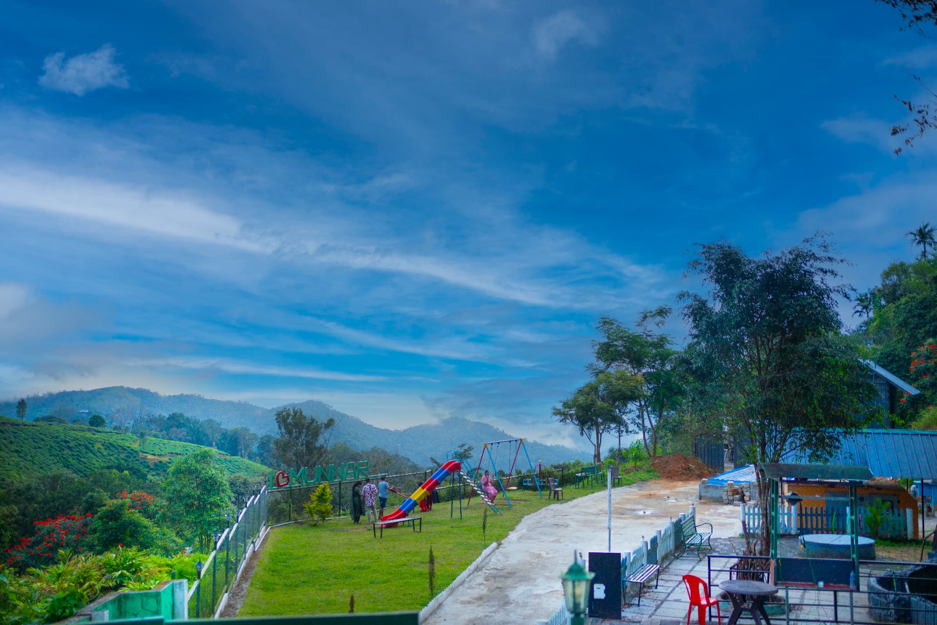 Lawn play area with slide and swings at Grand Valley Resort, Munnar, overlooking the tea hills